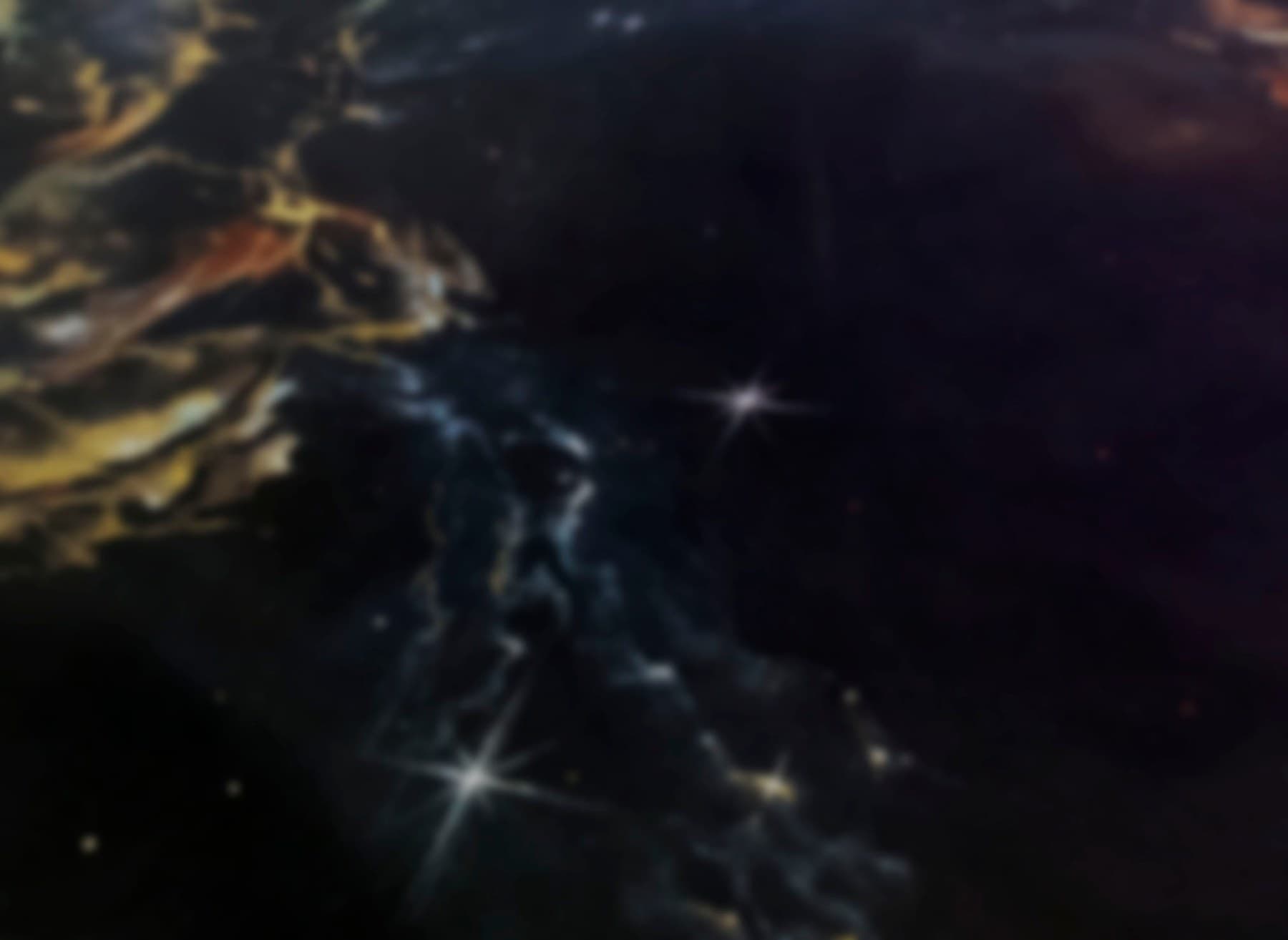 Fine white stars and wisps of gold and blue paint on black fabric.