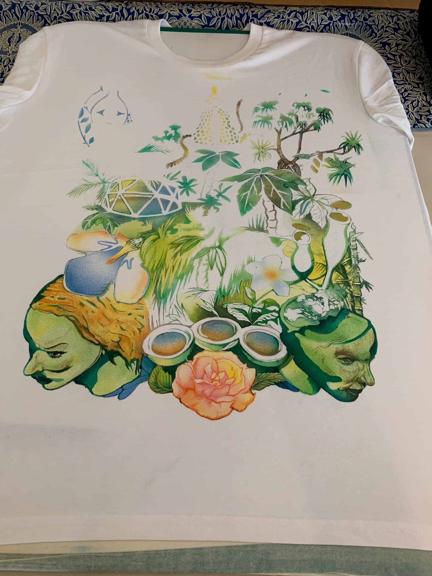 A white Jungle shirt laid flat with its colourful botanical painting.